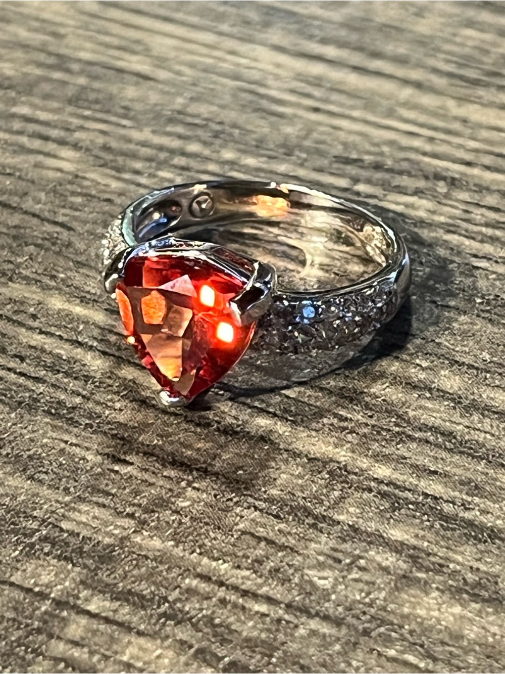 Sterling ring with reddish orange trillion center and cz accents. 925. Sz6